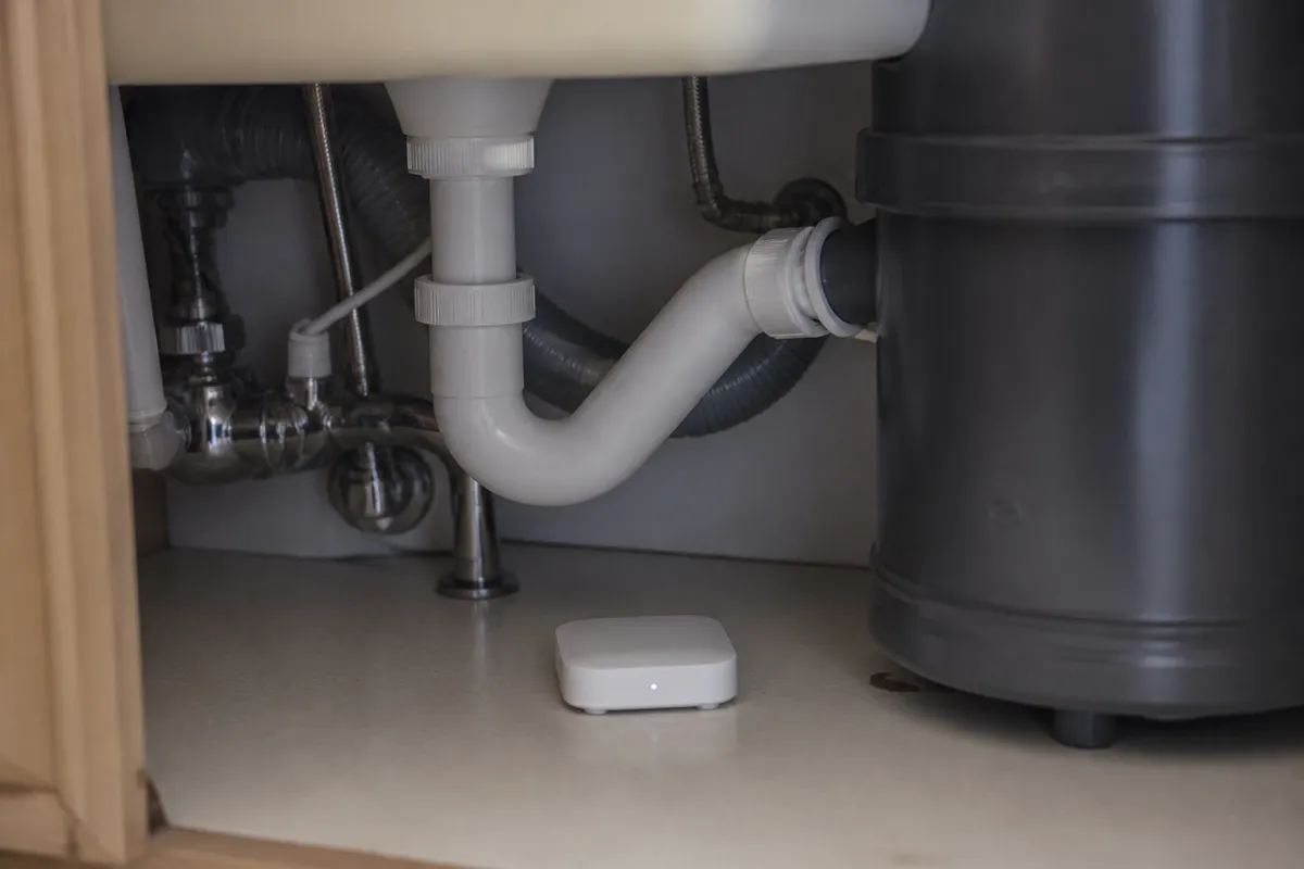 Detector de agua bajo mueble de cocina junto a tuberías
